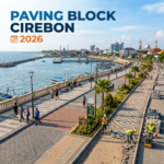Workers installing paving blocks along a seaside promenade in Cirebon with people walking nearby